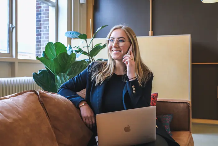 businesswoman sat smiling whilst making a phone call
