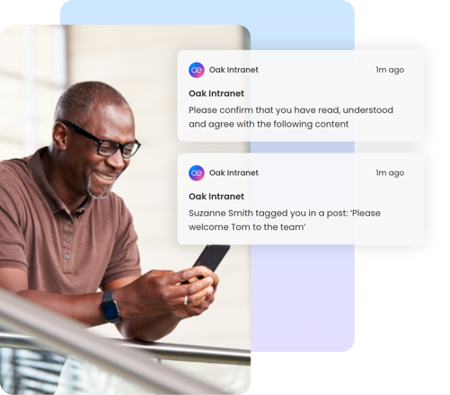 Man smiling at phone with Oak Intranet must-read document notifications displayed.