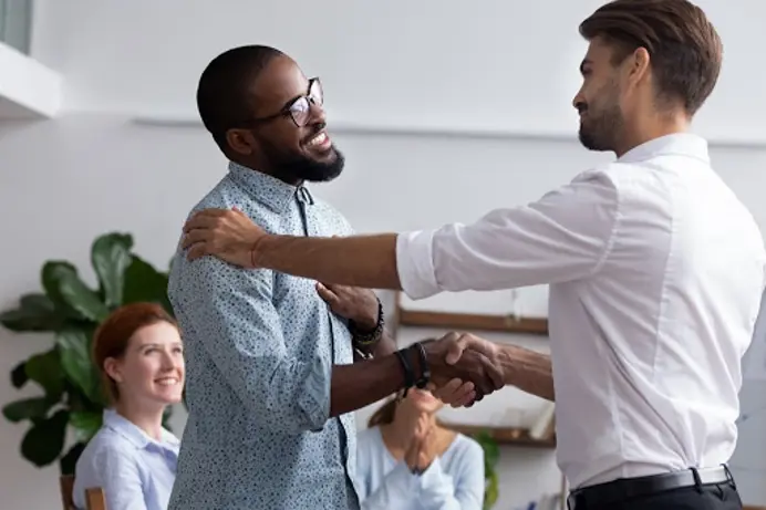 An image of two people in the workplace shaking hands